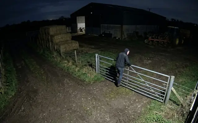 A single worker isolated in a remote corner of a large industrial site at dusk