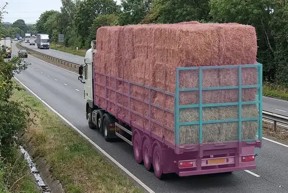 AI segmentation flagging an overloaded trailer with bales stacked above its side rails