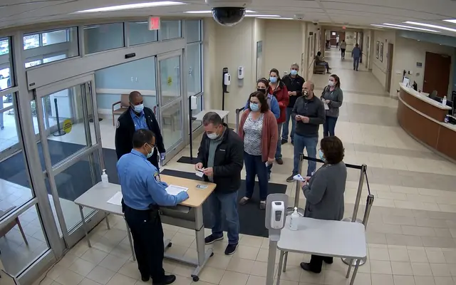 A crowded site entrance at shift start with many workers entering at once