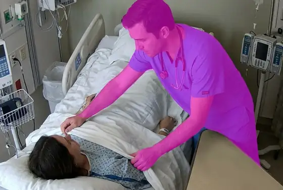 AI segmentation mask on a clinician without examination gloves at a patient bedside