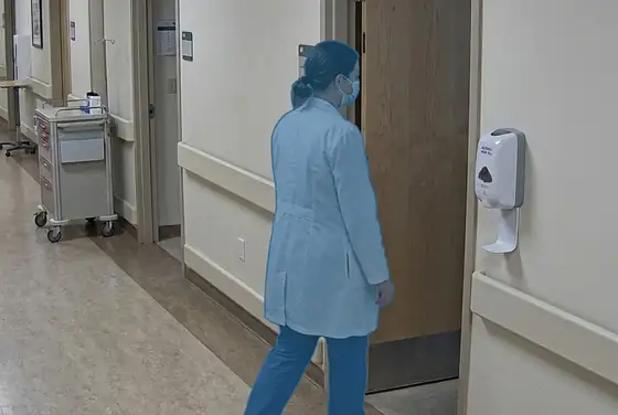 AI segmentation mask on a clinician leaving a patient room without using the alcohol gel dispenser