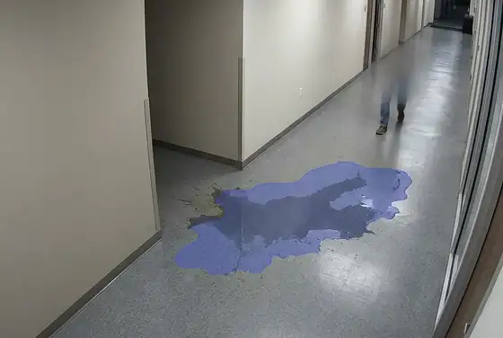 AI segmentation mask on a wet floor after a spill, slip-hazard detection in a corridor
