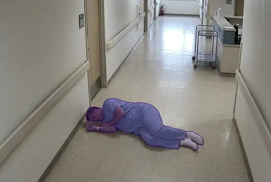 AI segmentation mask on a fallen patient lying on a hospital corridor floor