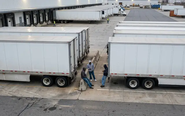 A worker at the unprotected edge of a high concrete slab without a fall-arrest harness