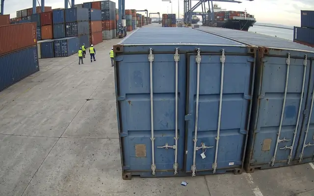 An emergency exit doorway blocked by stacked boxes and debris