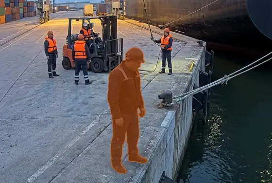 AI segmentation flagging a dock worker without a life vest near the quay edge
