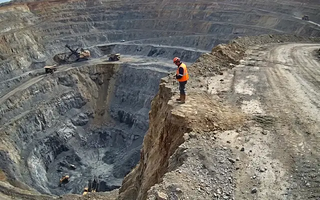 A worker at the unprotected edge of a high concrete slab without a fall-arrest harness