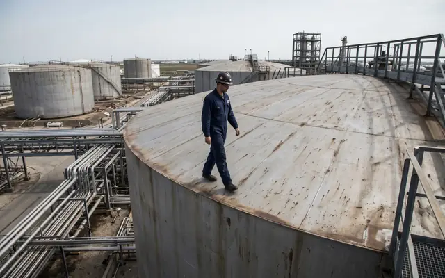 A worker at the unprotected edge of a high concrete slab without a fall-arrest harness