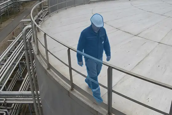AI segmentation mask flagging a worker on a tank roof without a fall-arrest harness