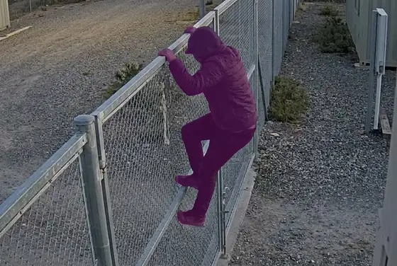 AI segmentation mask highlighting a person climbing a remote-site gate