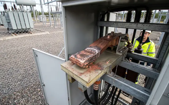 A medium-voltage switchgear panel with discolored cable termination lugs