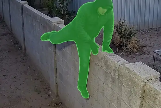 AI segmentation mask on a person climbing over a compound wall