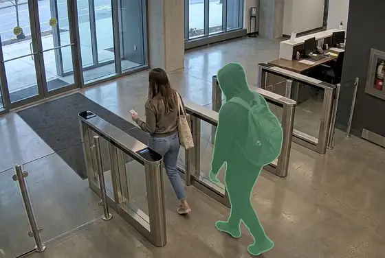 AI segmentation mask on a person tailgating behind a resident through a tower lobby turnstile