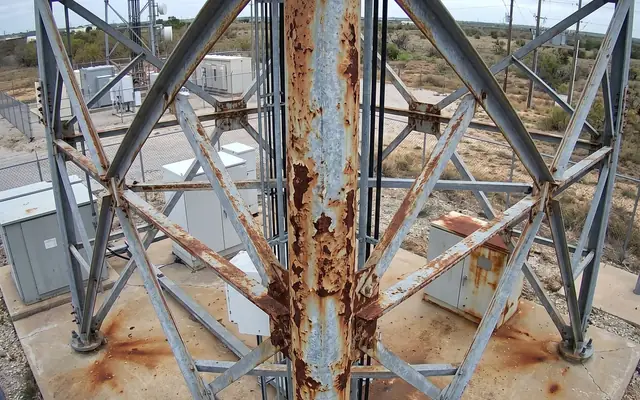 A bare-headed worker without a hard hat among colleagues wearing helmets on a construction site