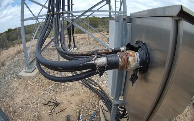 A worker at the unprotected edge of a high concrete slab without a fall-arrest harness