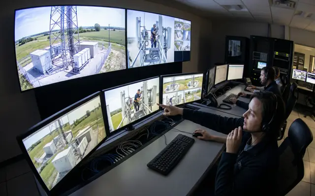 Operators in a modern safety control room verifying alerts on a video wall