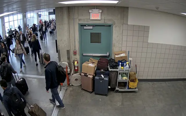 An emergency exit doorway blocked by stacked boxes and debris