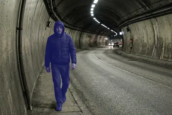 AI segmentation mask highlighting a pedestrian walking inside a road tunnel