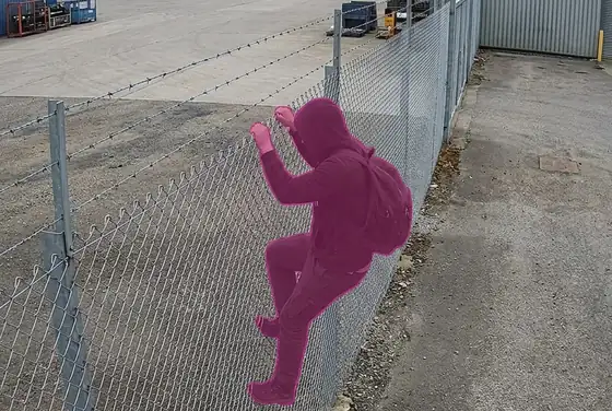 AI segmentation mask flagging a person climbing a perimeter fence at a depot