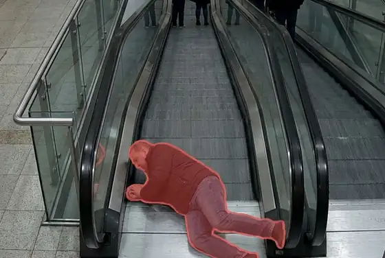 AI segmentation mask flagging a person fallen on a moving escalator