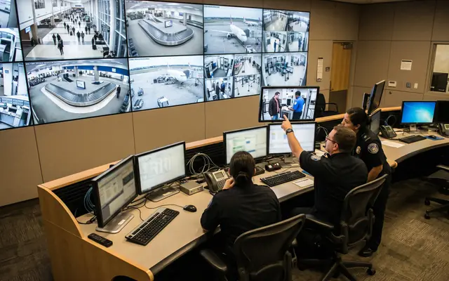 Operators in a modern safety control room verifying alerts on a video wall