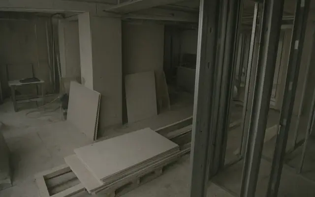 An emergency exit doorway blocked by stacked boxes and debris