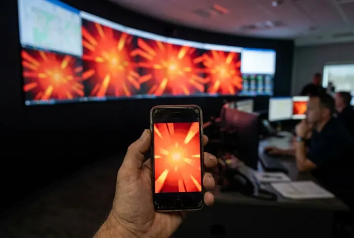 A supervisor phone and a control-room wall lighting up with the same alert